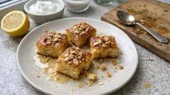 Αφράτη γιαουρτόπιτα-κέικ με σιρόπι λεμονιού και αμύγδαλα — πετυχαίνει πάντα